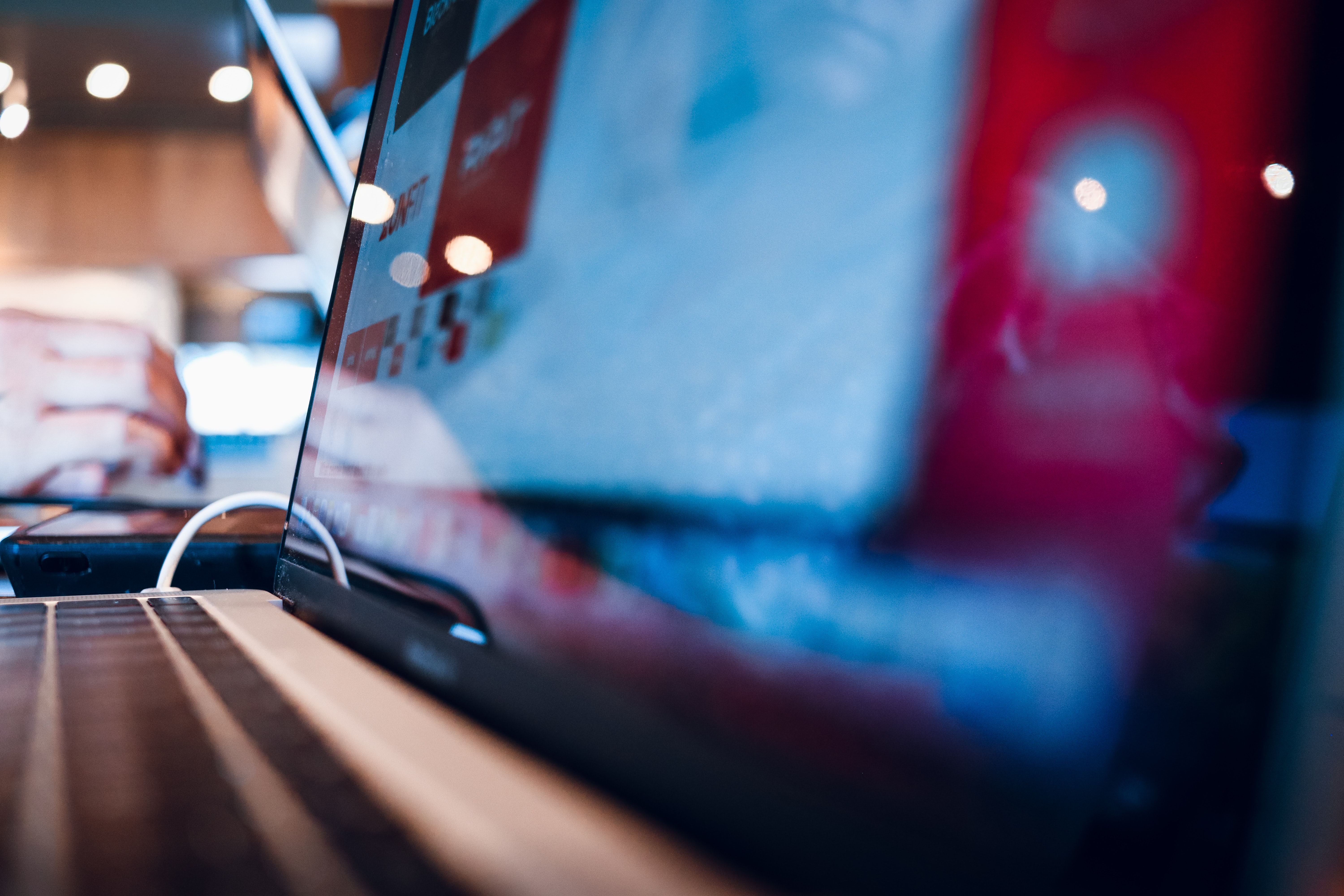 Typing from a coffee shop with creative design work on screen